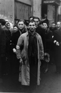 Groupe d'hommes juifs ôtant leur chapeau devant le photographe allemand.